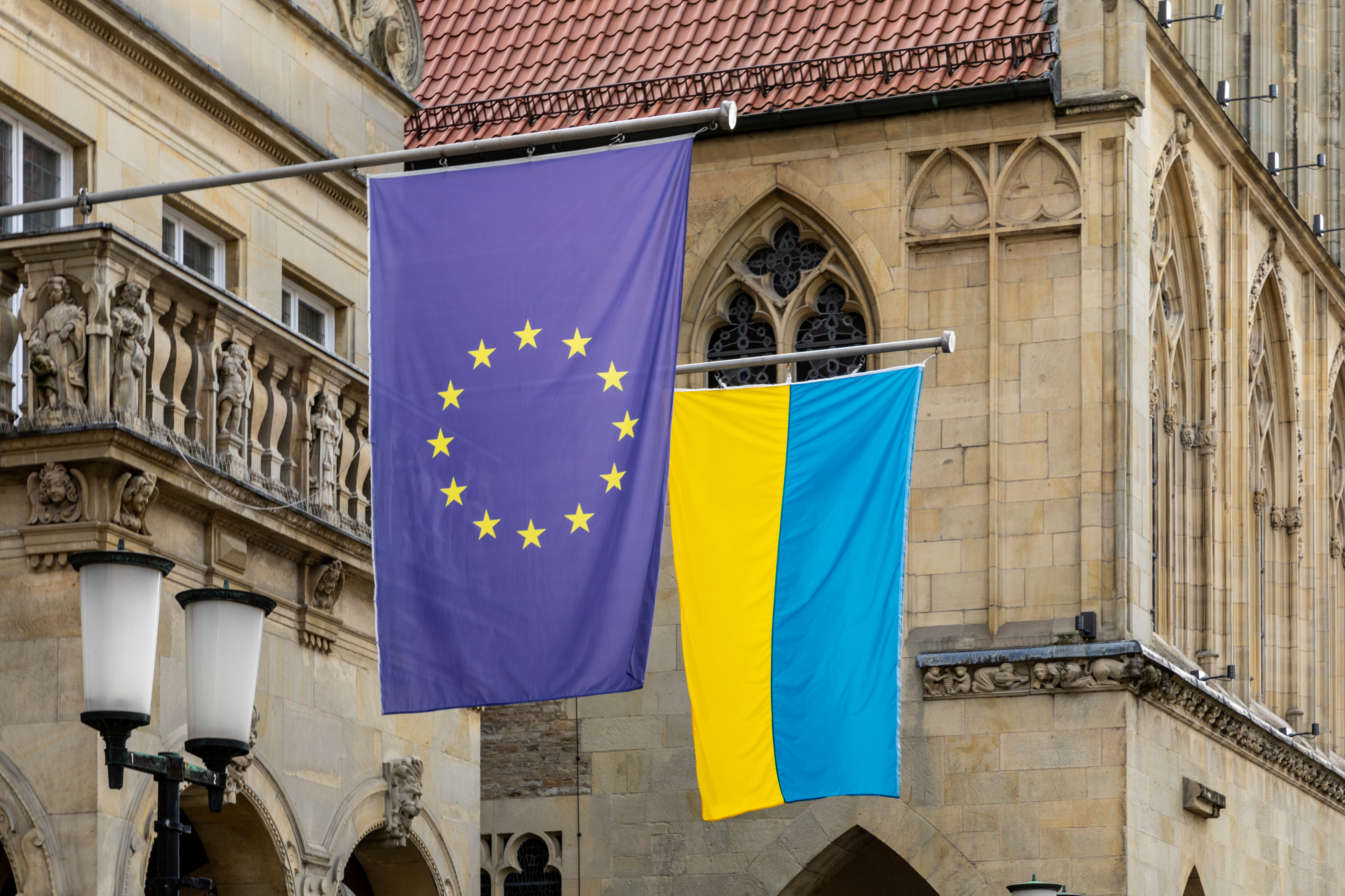 Photo: Flags (European Union and Ukraine) at the Stadtweinhaus on Prinzipalmarkt in Münster, North Rhine-Westphalia, Germany. Dietmar Rabich / Wikimedia Commons: https://commons.wikimedia.org/wiki/File:M%C3%BCnster,_Stadtweinhaus,_Beflaggung_Ukraine_und_EU_--_2022_--_0219.jpg